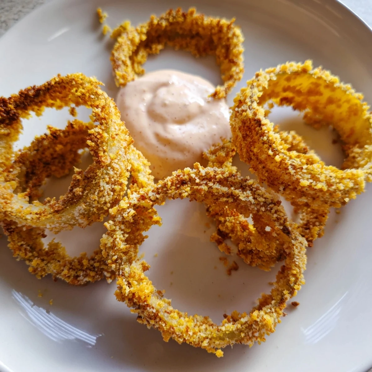Stacked golden Crispy Air Fryer Onion Rings with Spicy Burger Sauce on a plate, steam rising and ready to dip.