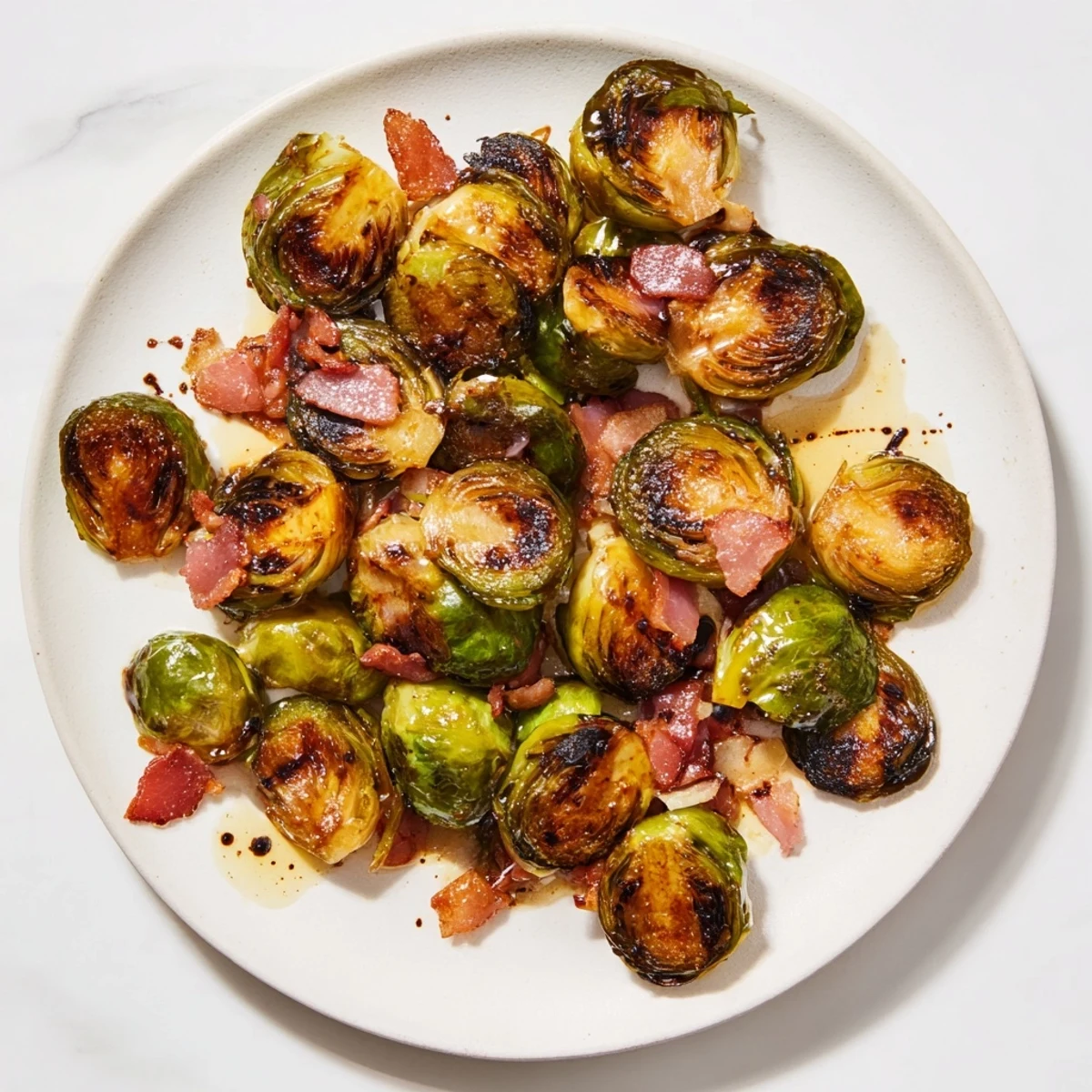 Golden roasted Brussels sprouts with crispy turkey bacon and optional balsamic drizzle on a baking sheet.
