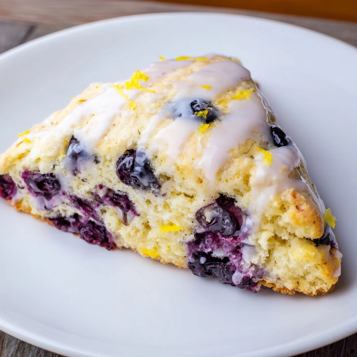 Golden Lemon Blueberry Scones with Sweet Vanilla Glaze drizzled over the tops, ready for breakfast or brunch.