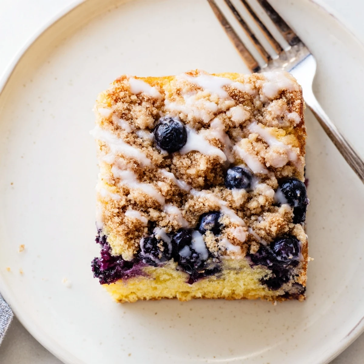 Warm Lemon Blueberry Coffee Cake with a buttery crumb topping, fresh blueberries, and a lemon glaze drizzle, perfect for a cozy brunch.