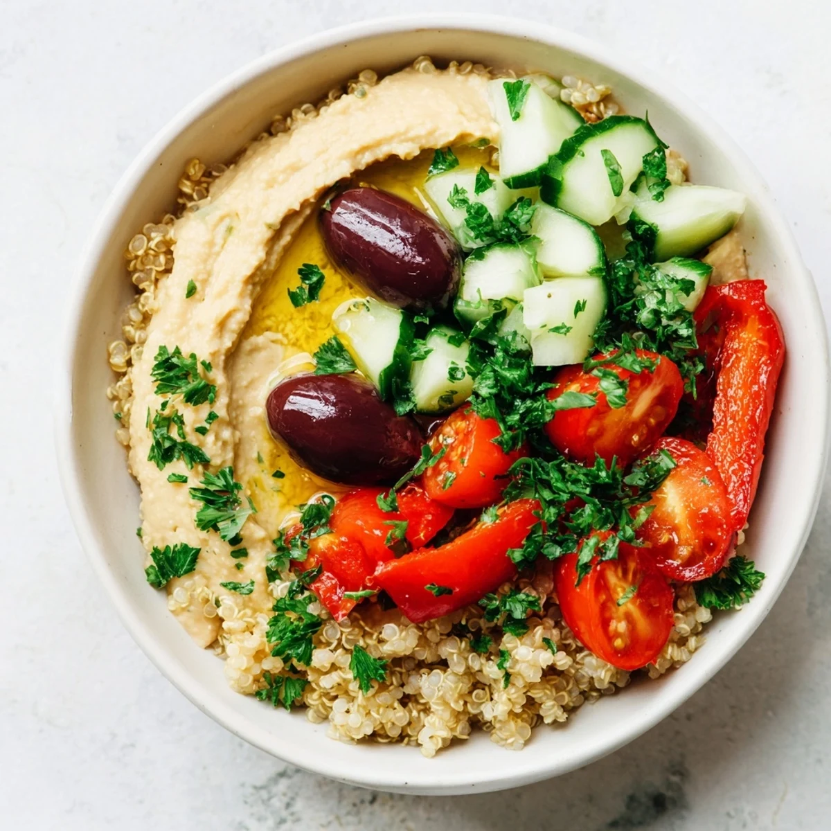 Savory Mediterranean Quinoa Bowl drizzled with olive oil and lemon, garnished with parsley, ready for a healthy vegetarian lunch.