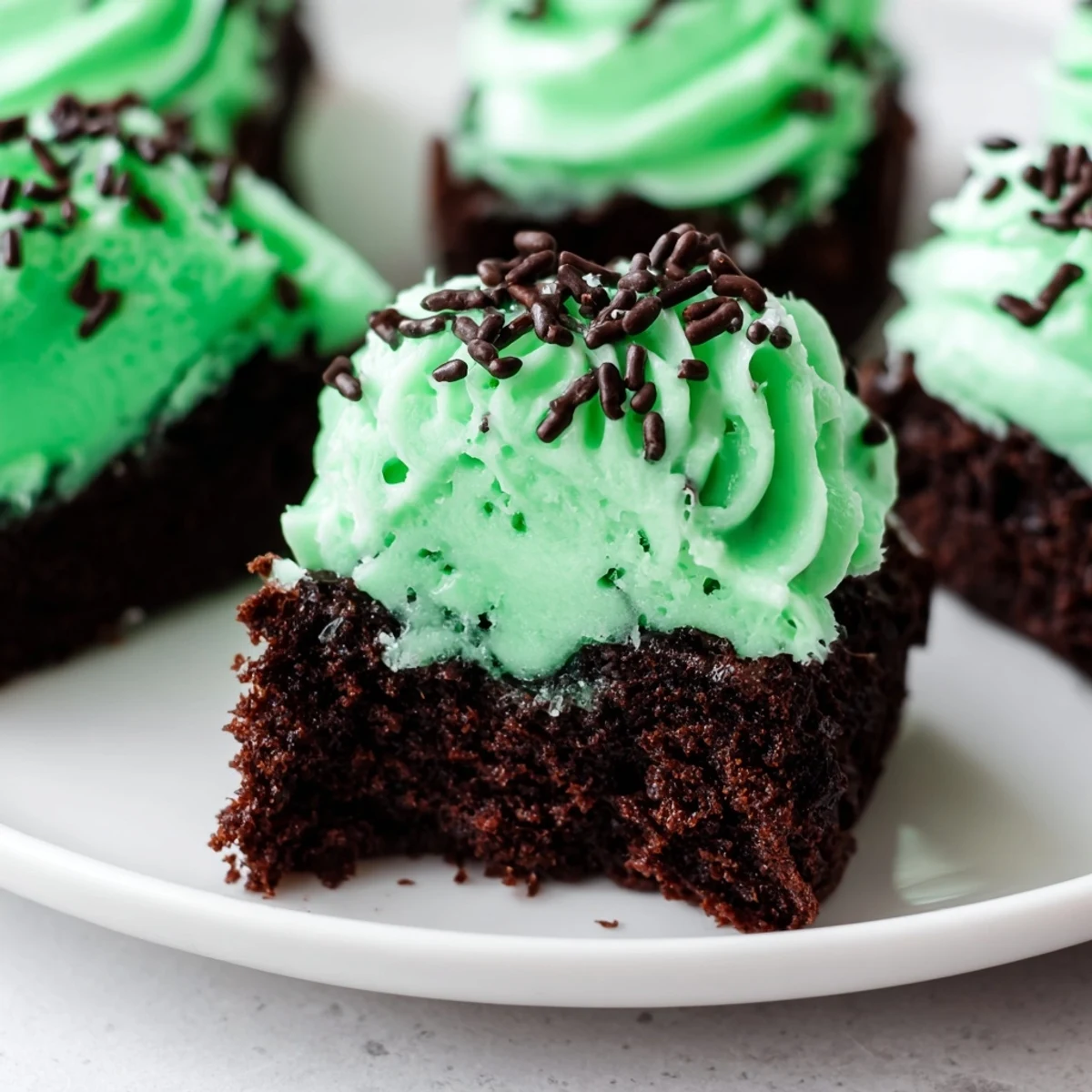 Close-up of St. Patricks Day Mint Brownie Bites with rich chocolate crumb and vibrant green frosting.  