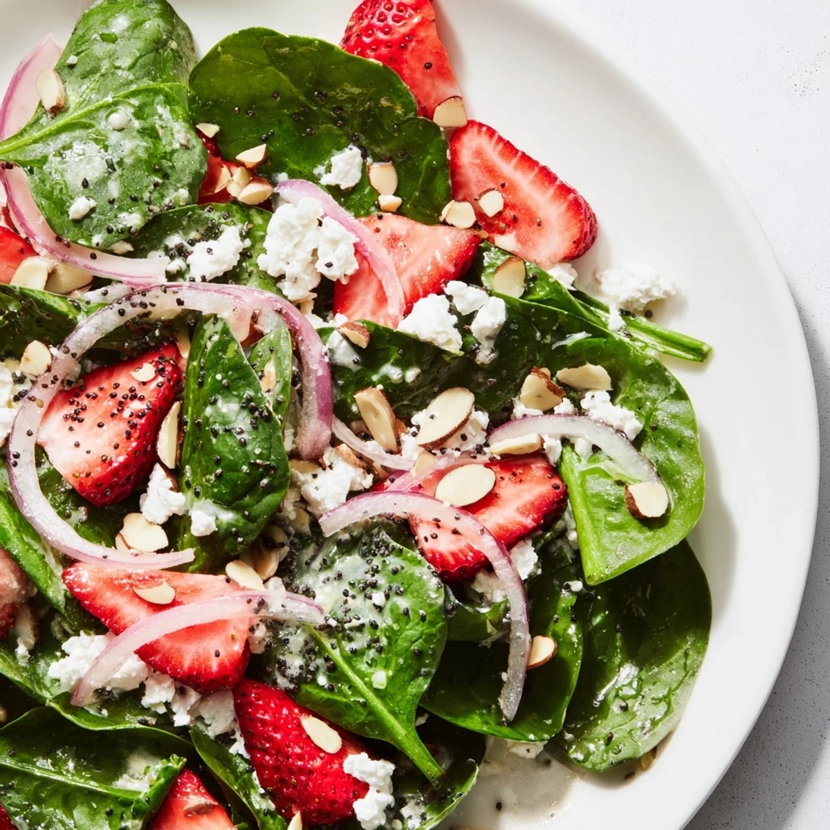 Serving a bright Strawberry Spinach Salad with Poppy Seed Dressing, perfect for spring picnics or a light vegetarian lunch.