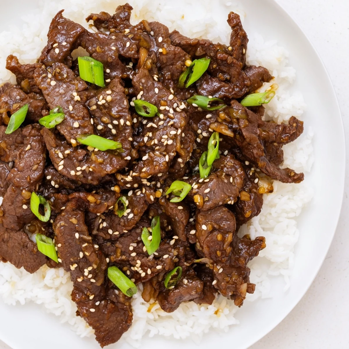 Slow-cooked flank steak simmered in rich Mongolian Beef sauce with garlic, ginger, and soy, served hot over rice.
