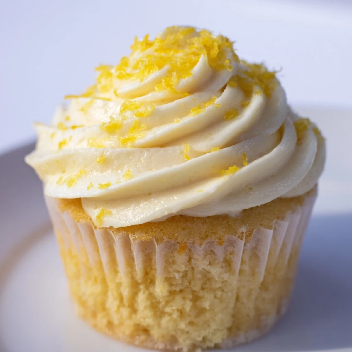 Moist Limoncello Cupcakes are garnished with fresh lemon slices, perfect for a refreshing Italian dessert.