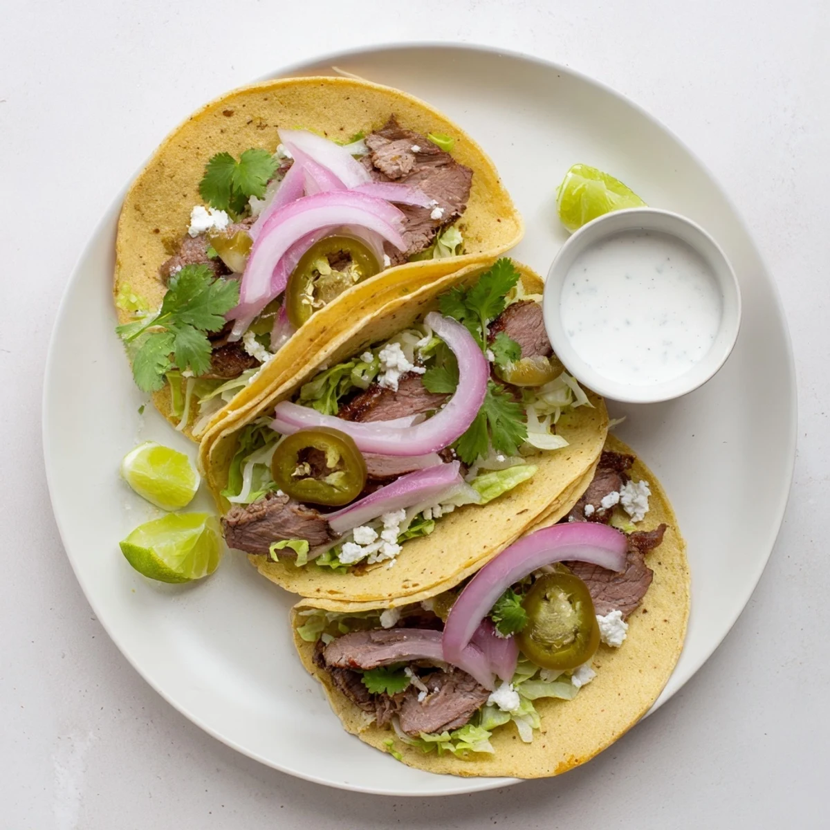 A platter displays warm corn tortillas topped with juicy slices of cumin crusted leg of lamb and fresh taco toppings.