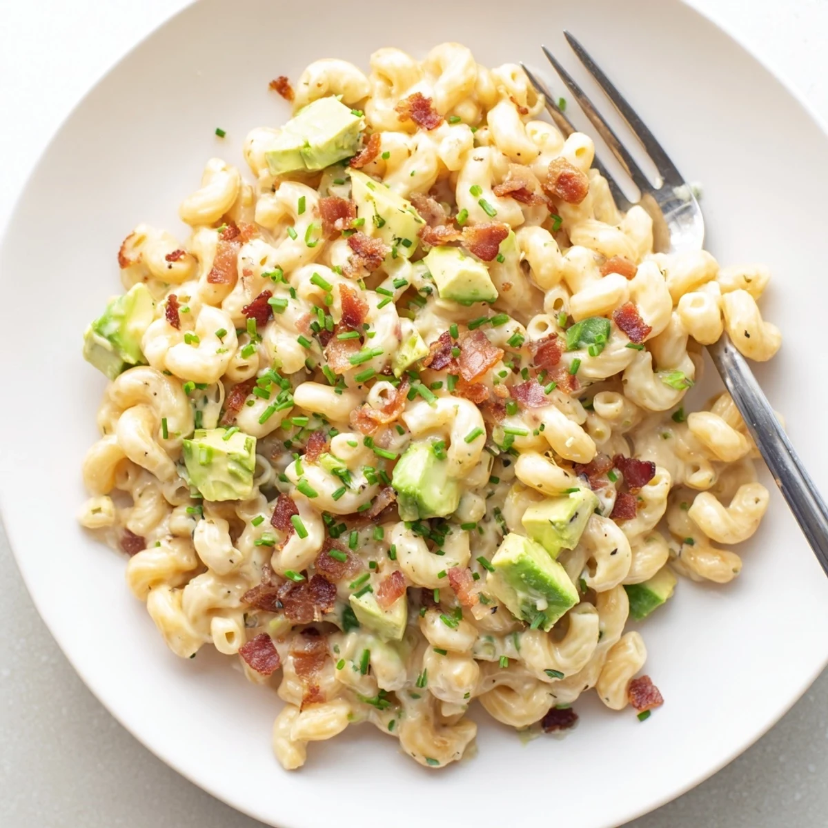 Savory Avocado and Bacon Mac and Cheese served hot, featuring a rich cheese sauce and green avocado chunks.
