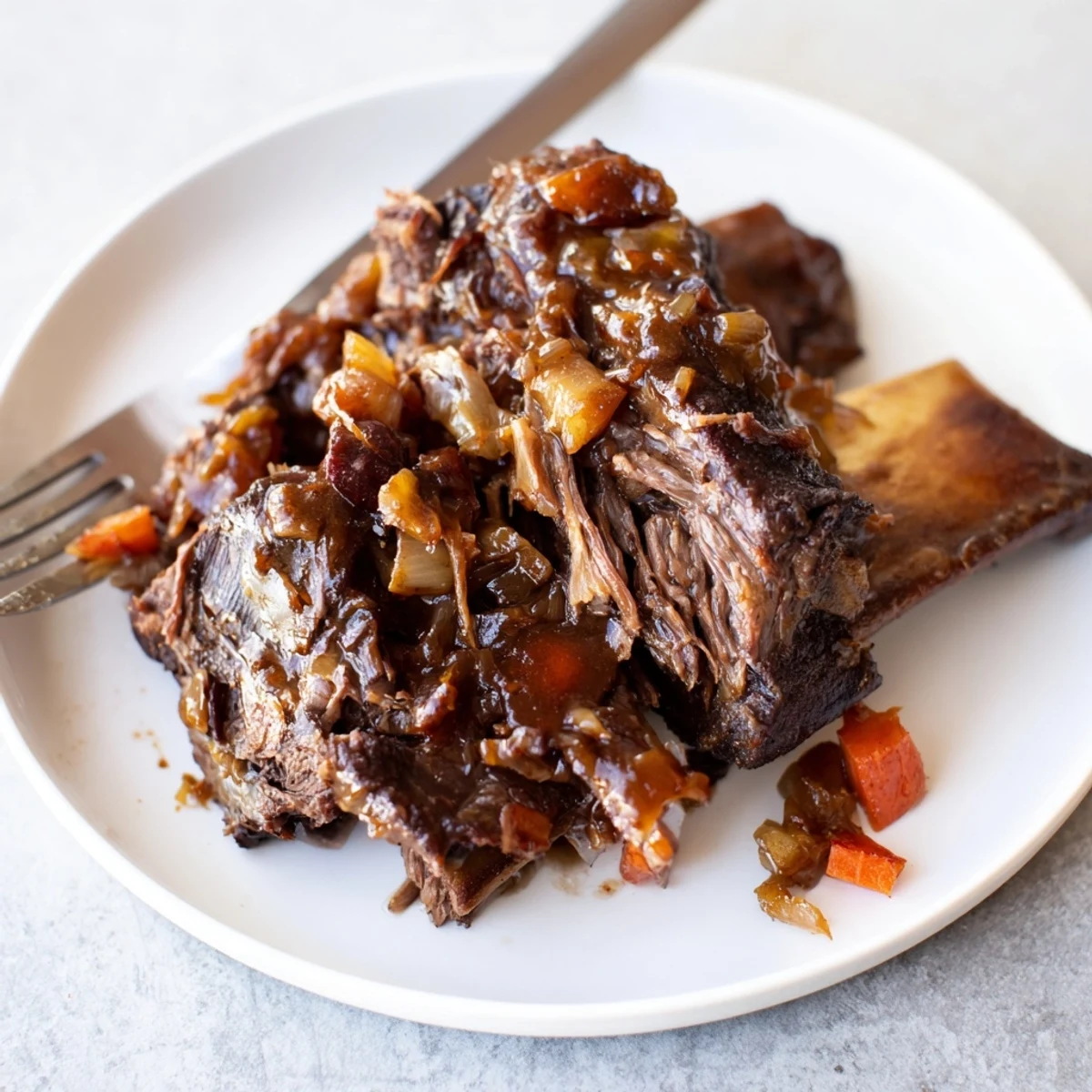 Tender maple bourbon glazed short ribs with shiny caramelized coating served over creamy mashed potatoes