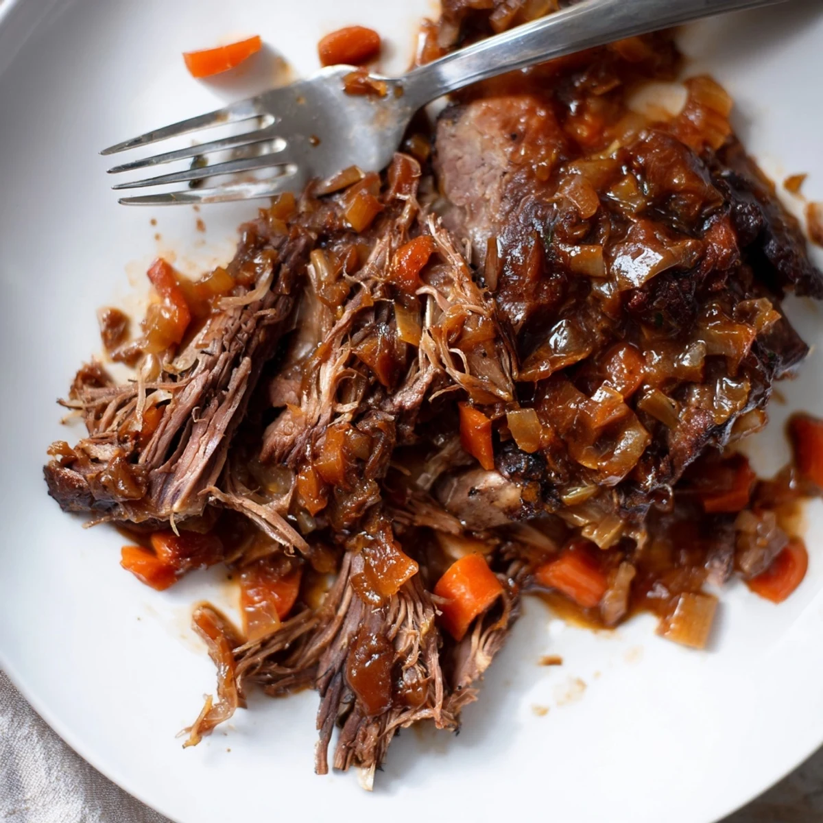 Fall-off-the-bone maple bourbon glazed short ribs plated with roasted vegetables and rich dark sauce drizzle