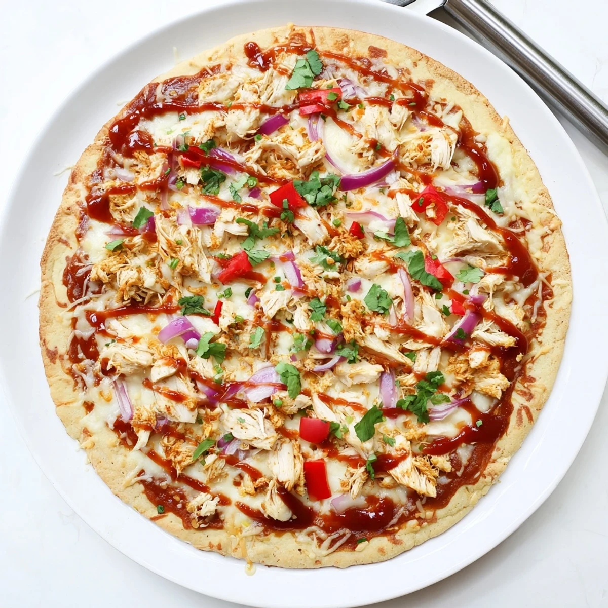 Delicious homemade BBQ chicken pizza with tangy sauce shredded chicken red onion strips cilantro garnish on golden crust