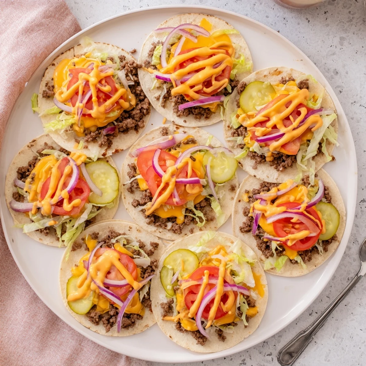 American Mexican fusion smash burger tacos topped with cheese, crisp onions, and burger sauce