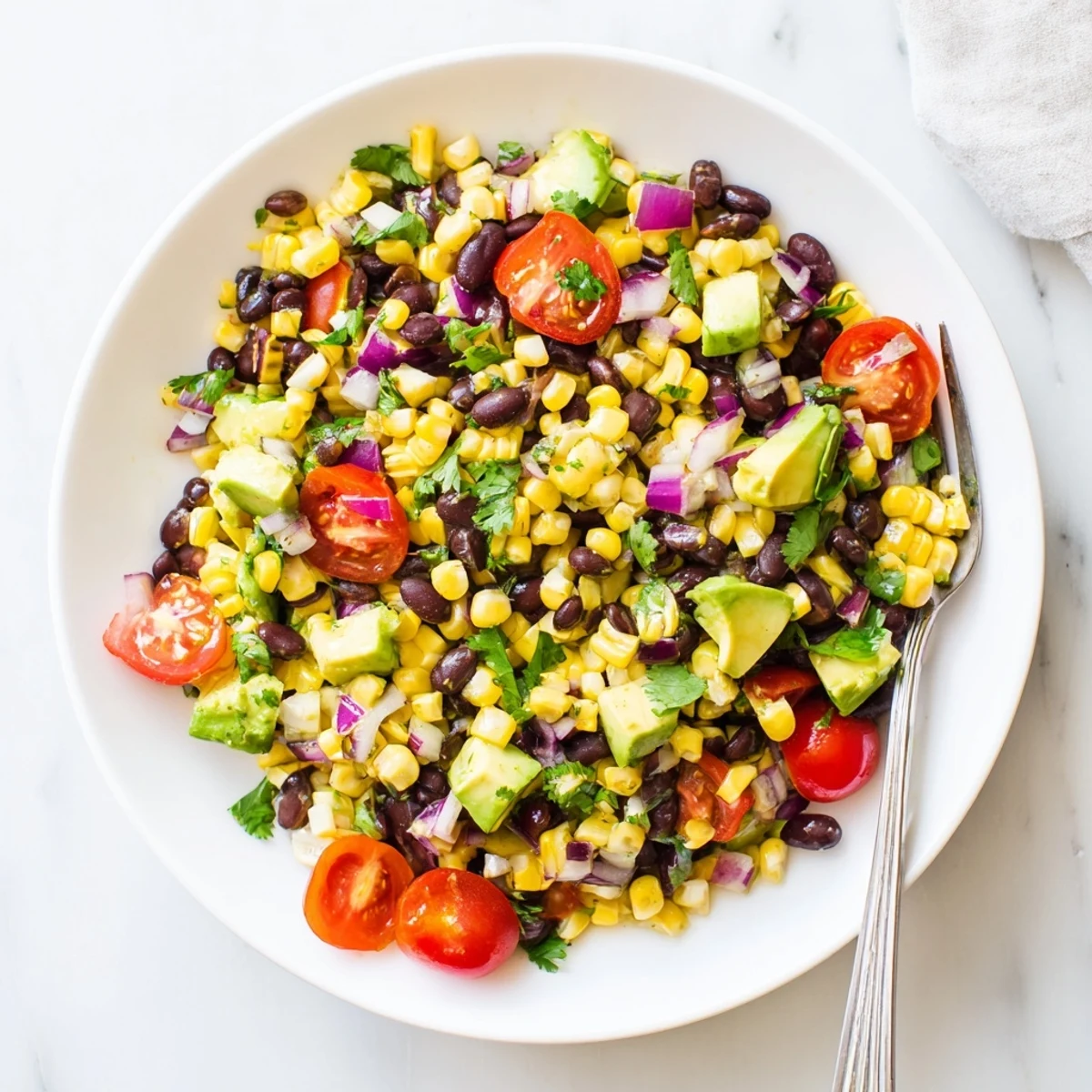 Vibrant summer salad featuring sweet corn, hearty black beans, crisp red bell peppers, and creamy diced avocado