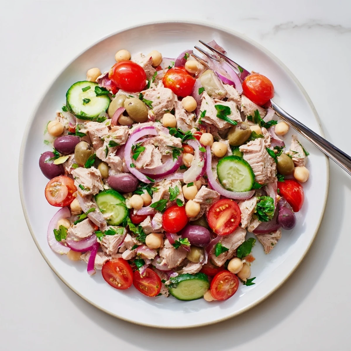 Golden bowl of hearty tuna and garbanzo bean salad tossed with crisp vegetables and zesty lemon dressing