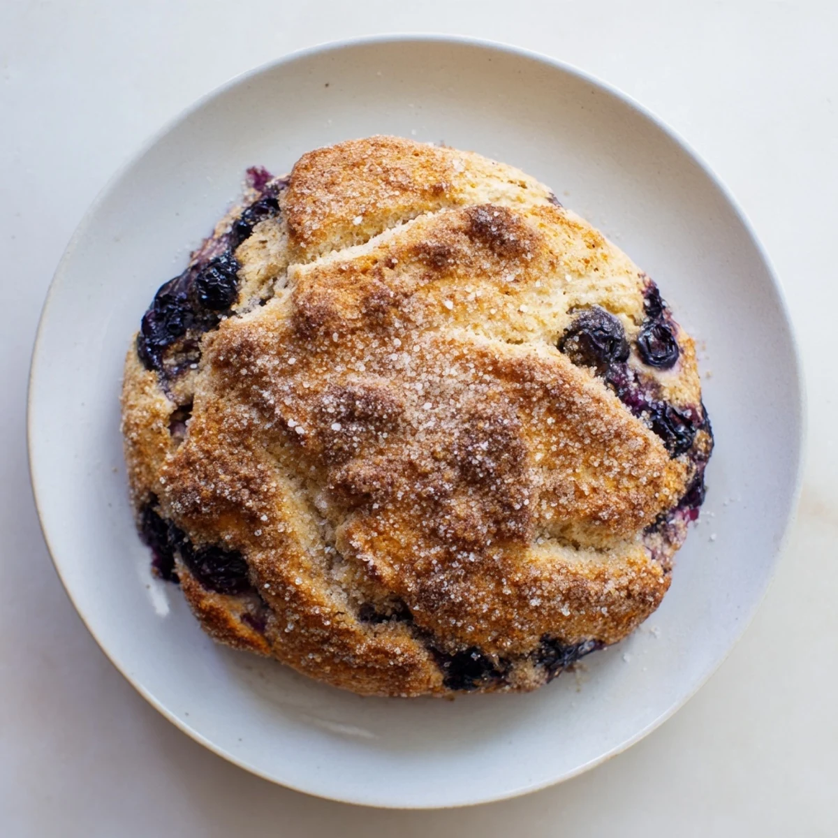Eight triangular scones with purple blueberry speckles finished with sugary cinnamon sprinkles