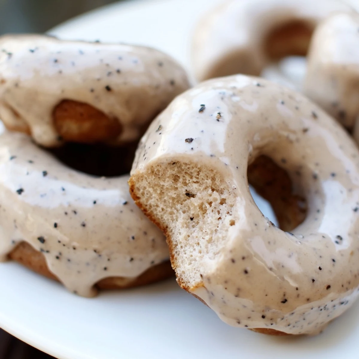 Golden brown Earl Grey mochi donuts topped with sweet white glaze on a wire rack