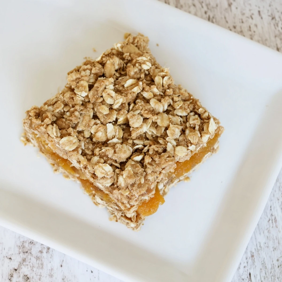 Golden brown gluten-free oatmeal apricot bars with sweet fruit filling and crumbly oat topping freshly baked