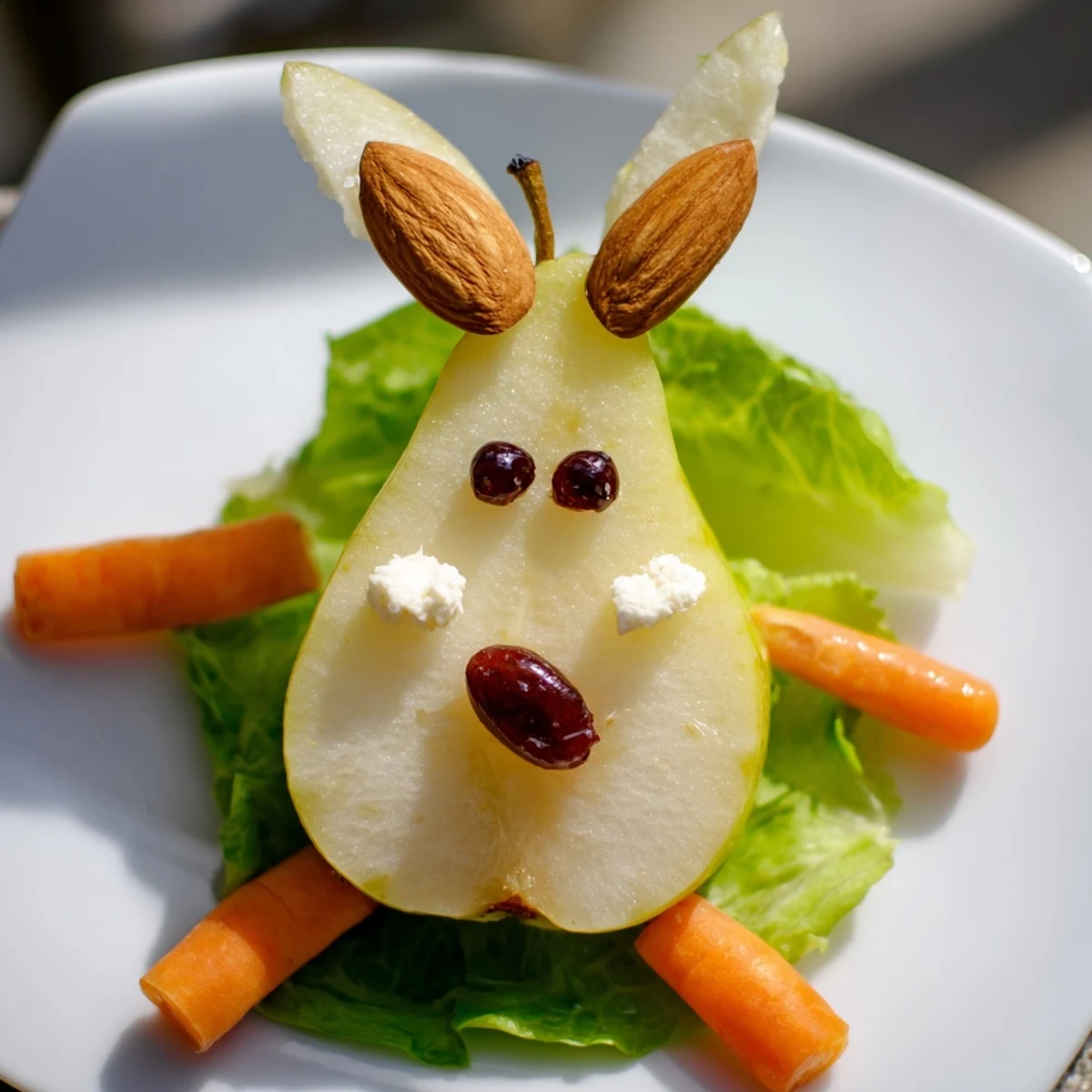 Adorable pear bunny salad arranged on lettuce leaves with cottage cheese tail and raisin eyes