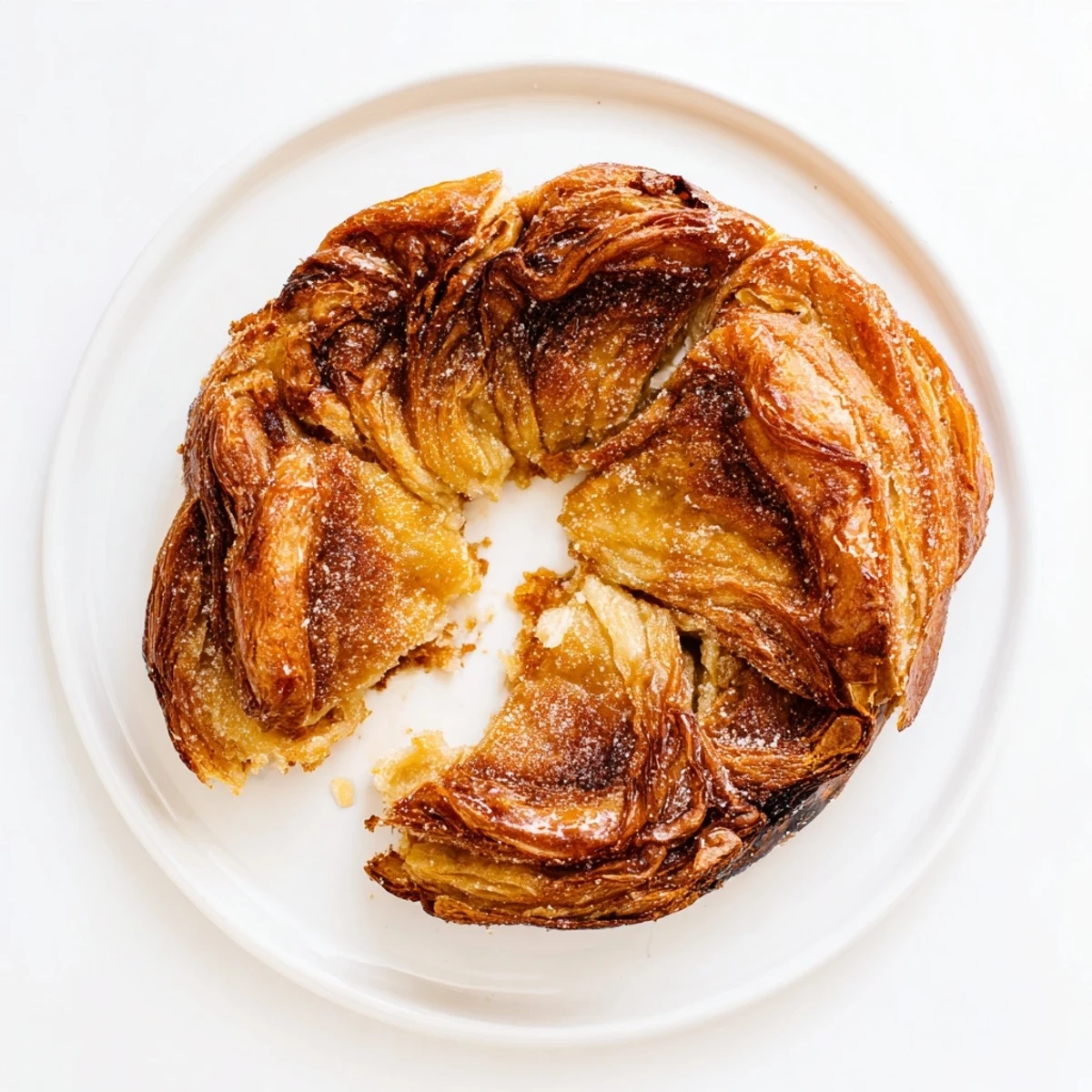 Freshly baked French Kouign Amann with caramelized sugar coating served warm on wire cooling rack