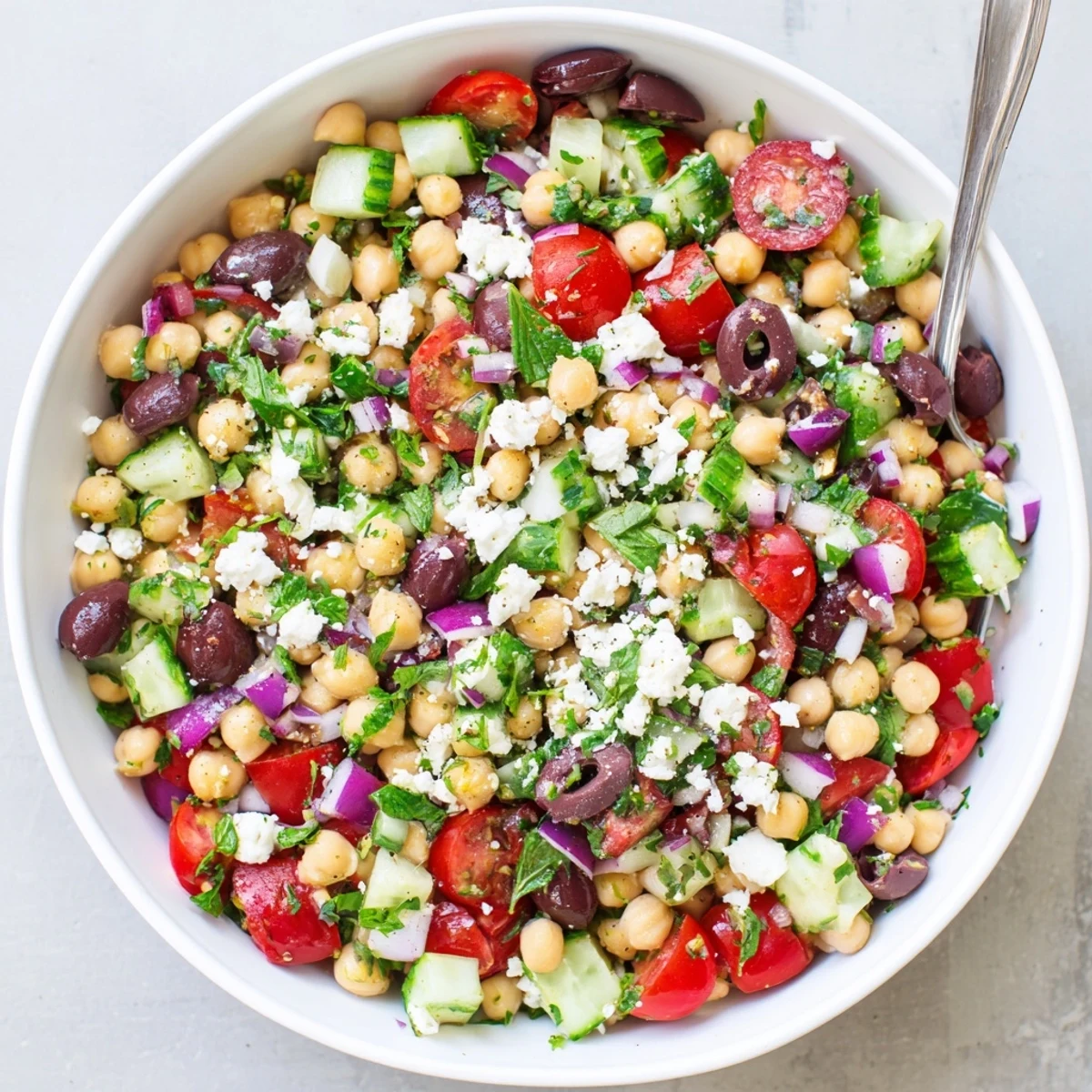 Colorful Mediterranean chickpea salad featuring crisp vegetables, tangy feta, and fresh herbs in a rustic bowl