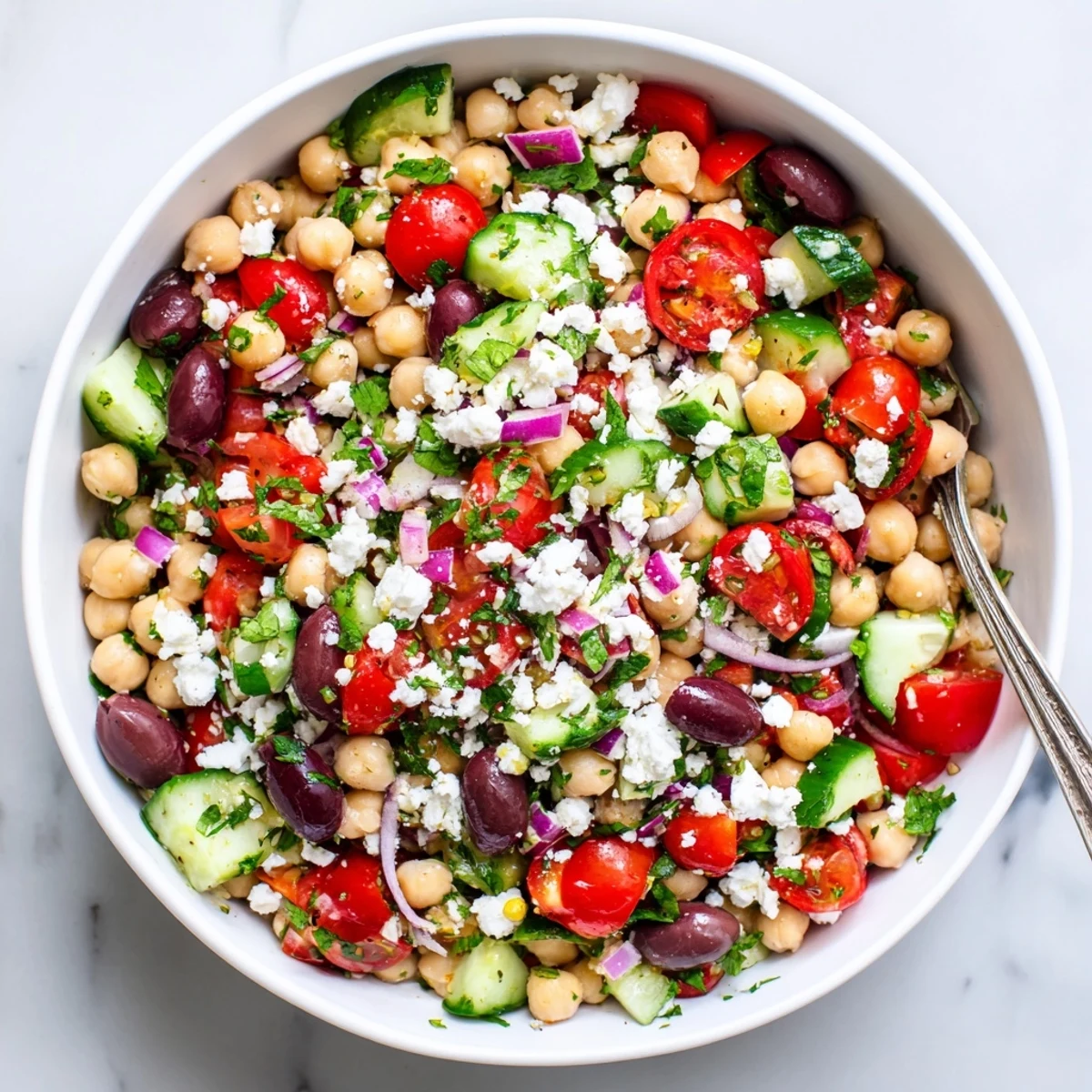 Protein-packed Mediterranean chickpea salad bowl with diced crunchy vegetables and creamy feta cheese crumbles