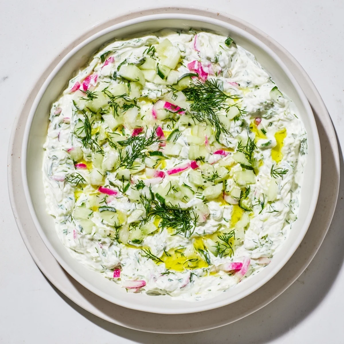 Close up of healthy radish tzatziki dip garnished with dill and olive oil drizzle