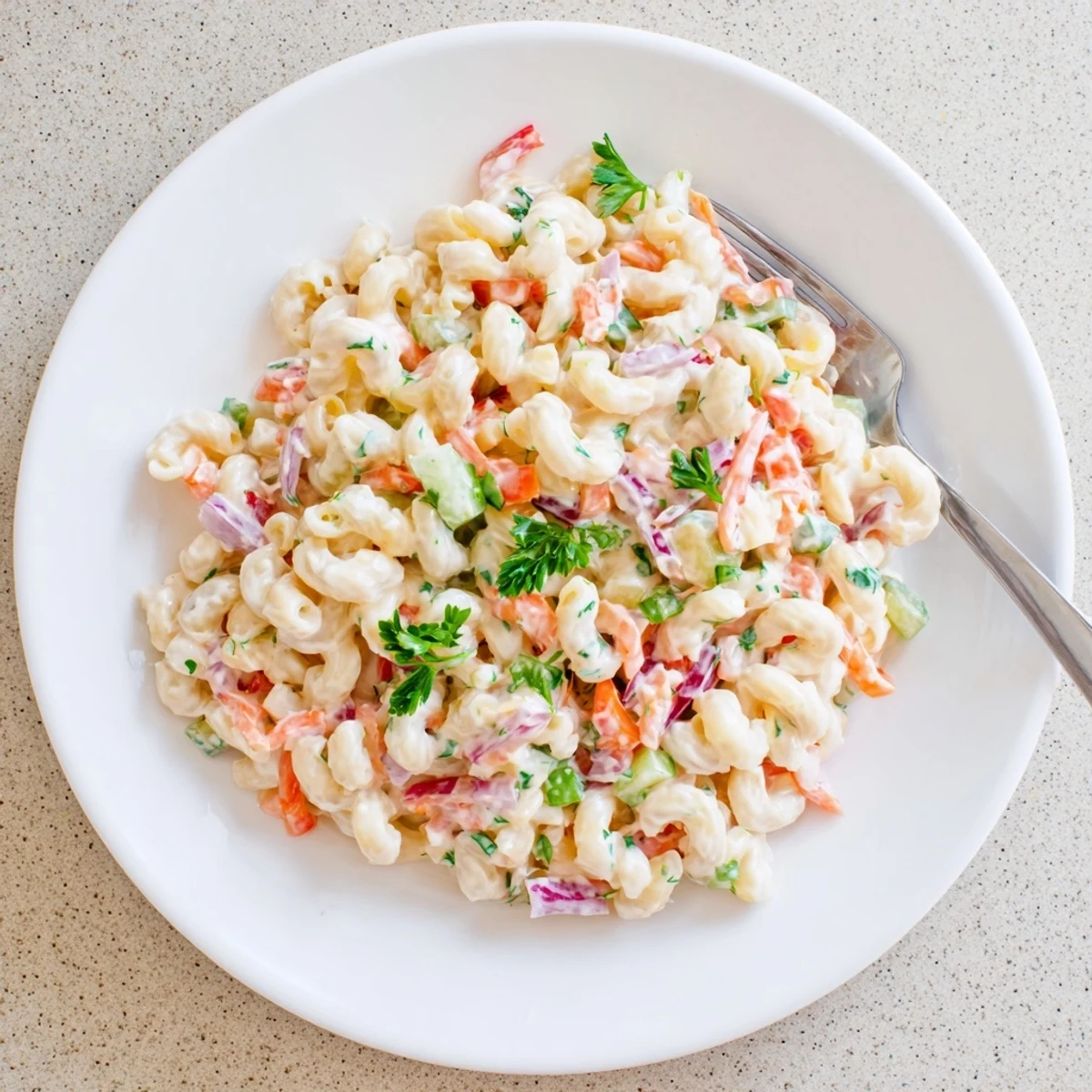 Classic macaroni salad coated in tangy dressing with crunchy red peppers and celery