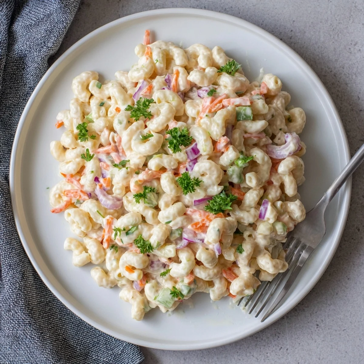 Cold macaroni salad featuring tender pasta and vibrant vegetables in creamy zesty sauce