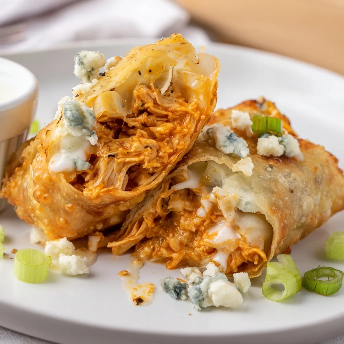 Steaming Buffalo Chicken Egg Rolls sliced open to reveal gooey cheese