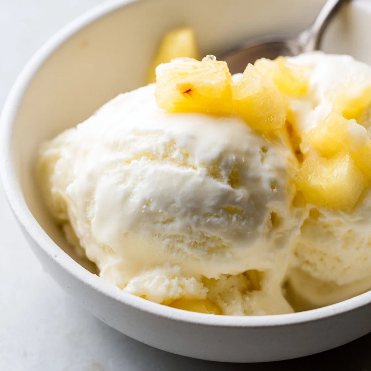 Creamy Pineapple Ice Cream Recipe: silky golden scoops topped with toasted coconut