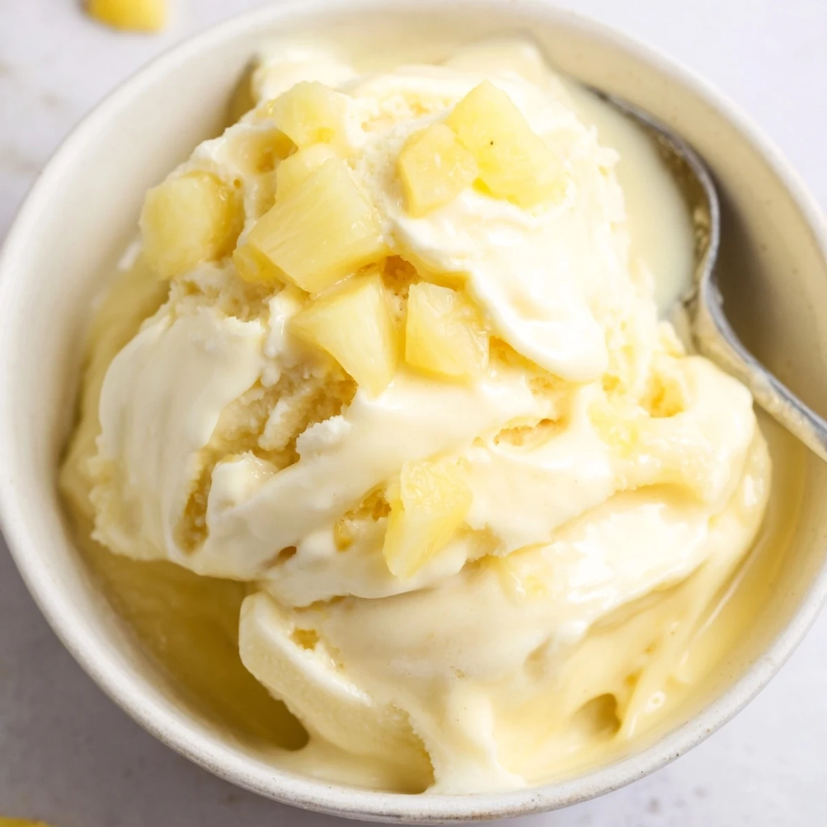 A chilled bowl of Creamy Pineapple Ice Cream with bright citrus aroma