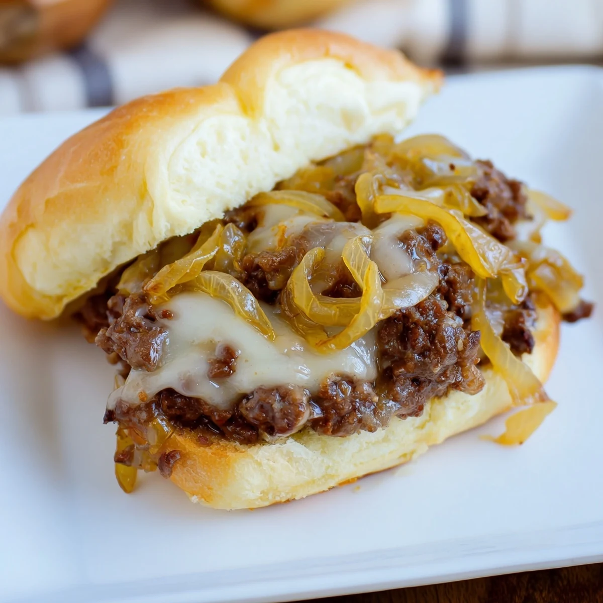 Savory ground beef mixture piled high on a soft bun characterizes these indulgent French onion beef sloppy joes