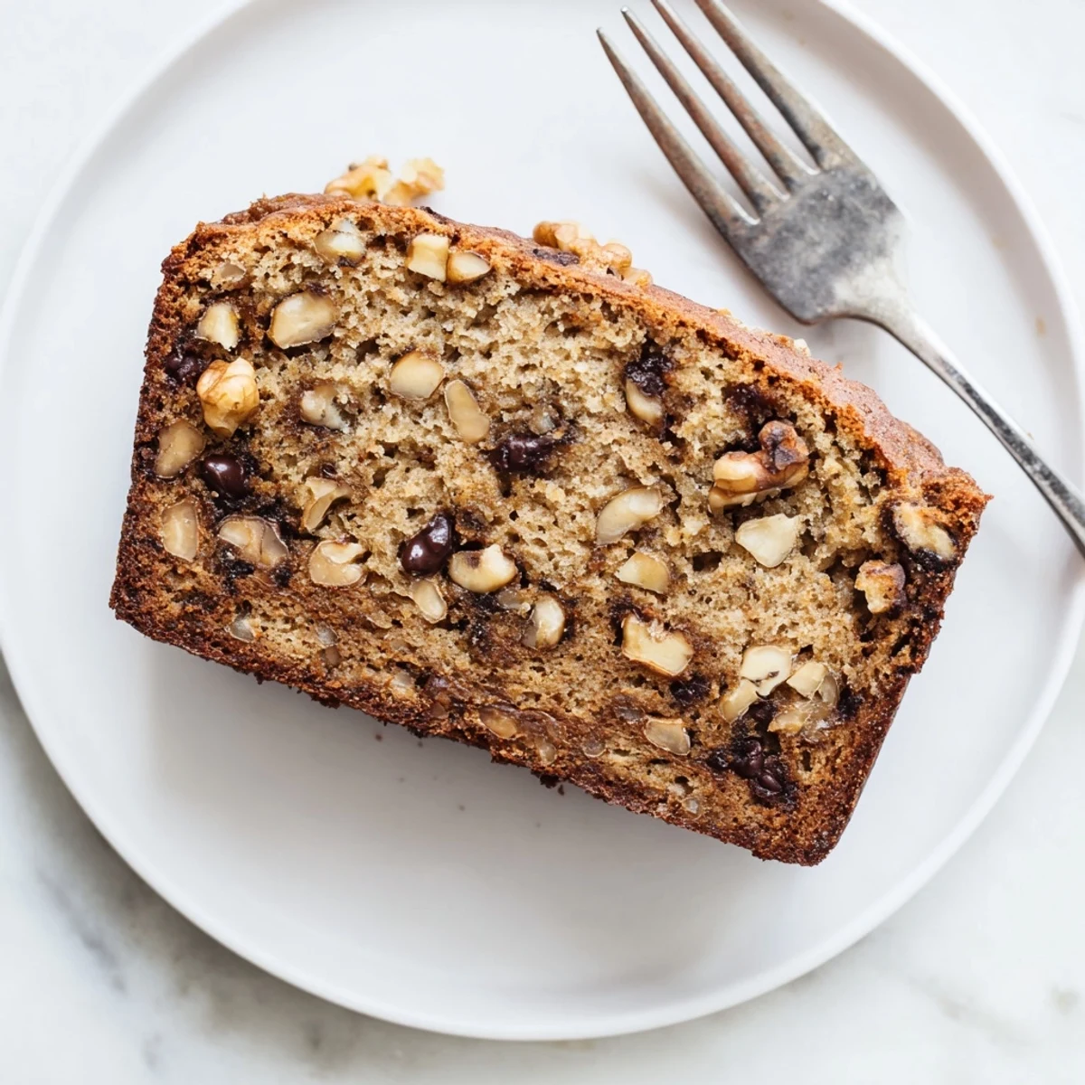 Golden protein banana bread oil free loaf sliced on wooden board with visible texture