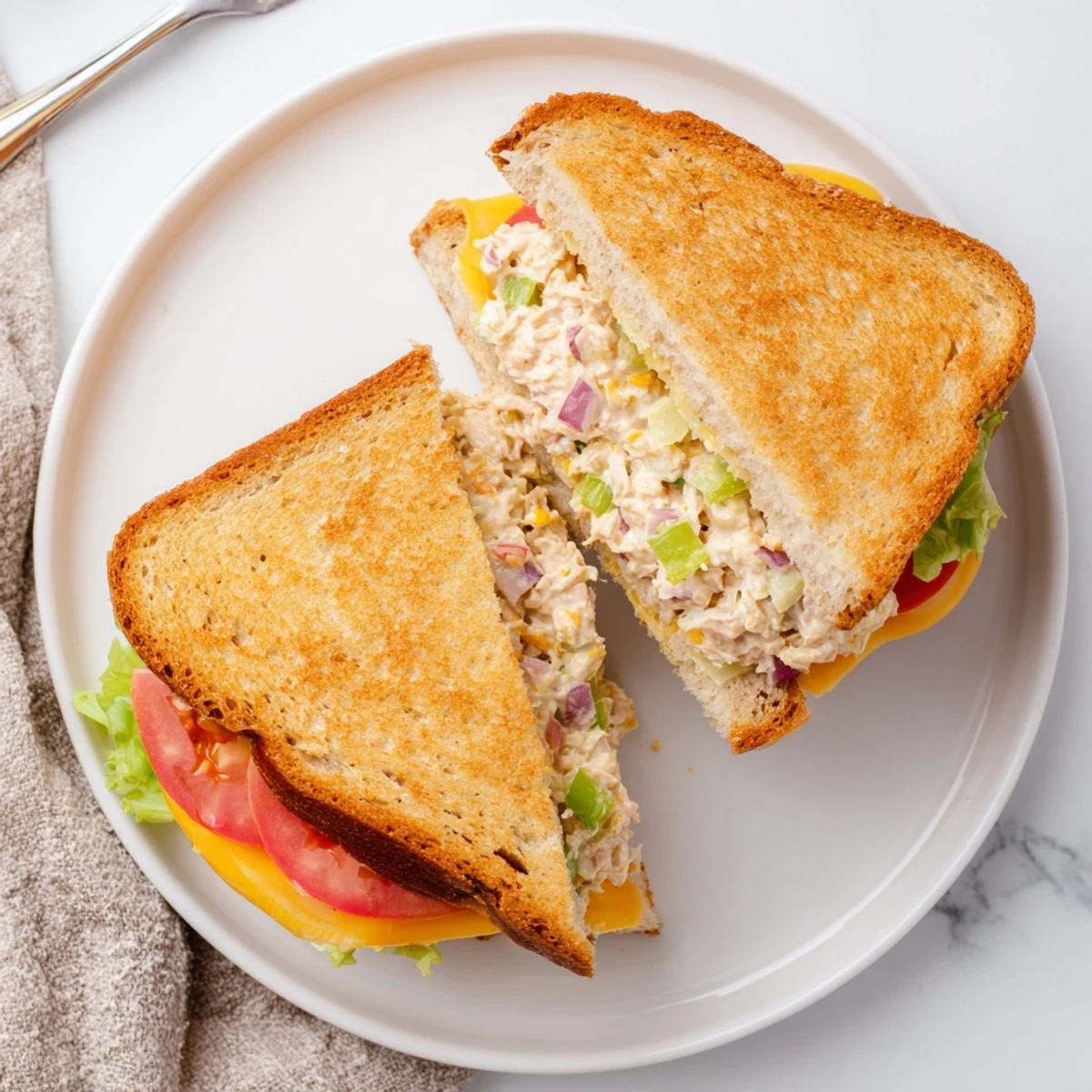 Golden grilled tuna melt sandwich with melted cheese oozing from crispy buttered bread