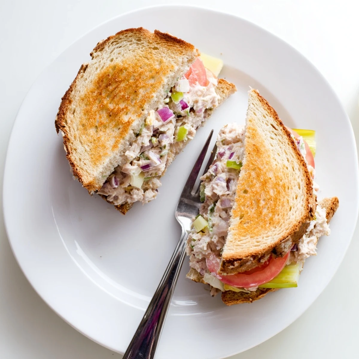 Sliced tuna melt sandwich revealing melted cheddar cheese and savory tuna filling inside