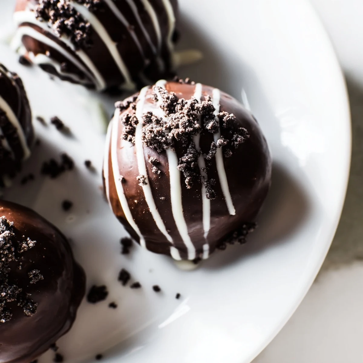 Bite-sized mint Oreo truffles coated in glossy dark chocolate with crushed cookie garnish