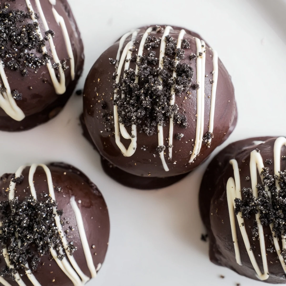 Dark chocolate-dipped mint Oreo truffles sprinkled with crushed mint cookies on parchment paper