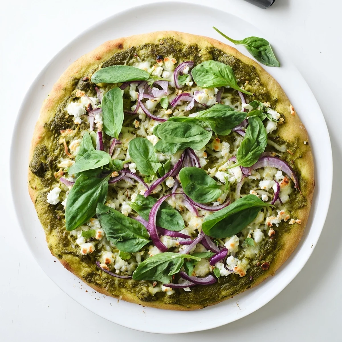 Homemade green pizza with vibrant broccoli pesto, melted mozzarella, and fresh arugula atop golden crust