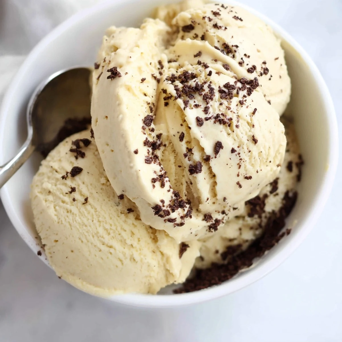 Vegan banana nice cream swirling in a glass jar with cocoa powder dusted on top for chocolate flavor