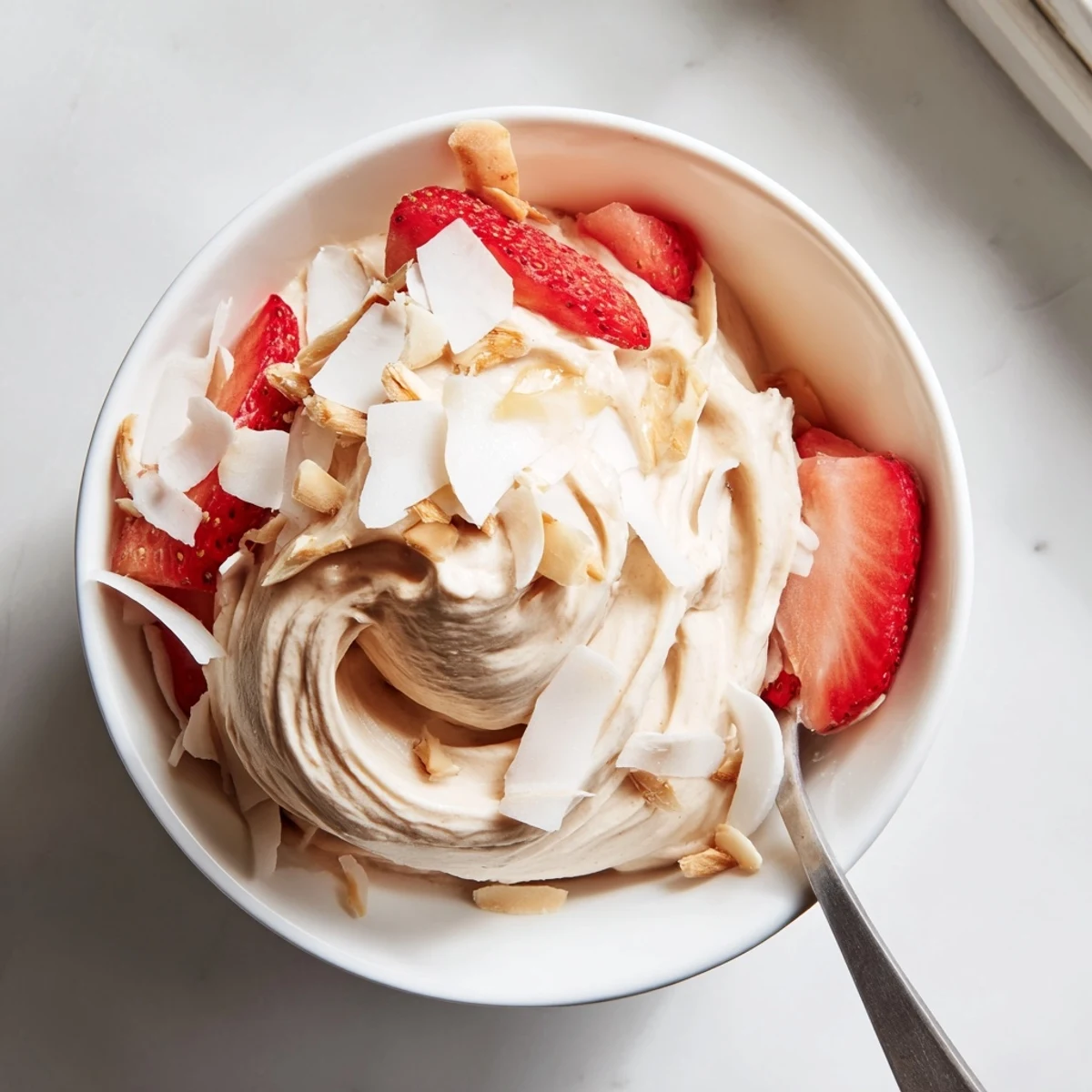 Creamy healthy nice cream recipe scooped into bowls topped with fresh berries and coconut flakes