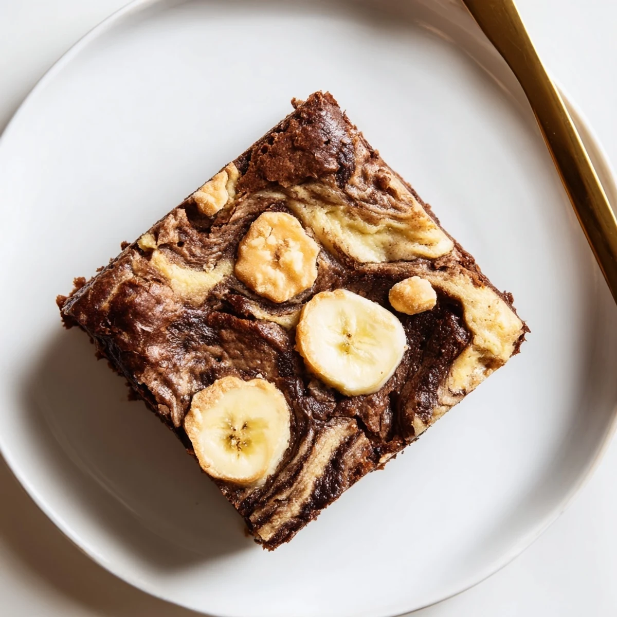 Sliced Banana Pudding Brownies plated with vanilla ice cream and banana slices