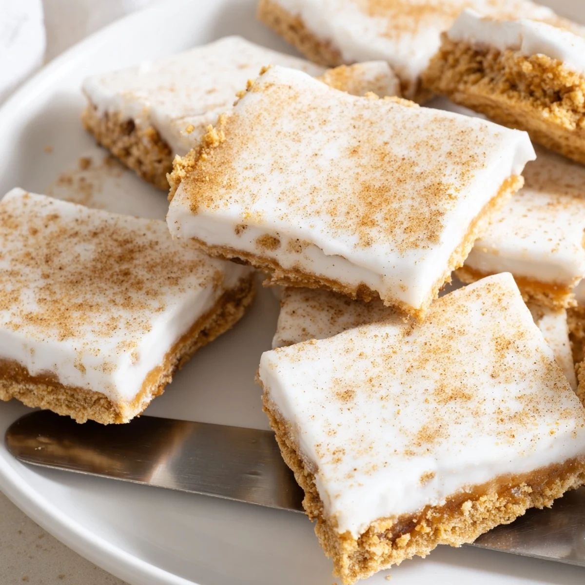 Melted white chocolate and cinnamon dust coating crispy Churro Saltine White Toffee pieces in pan