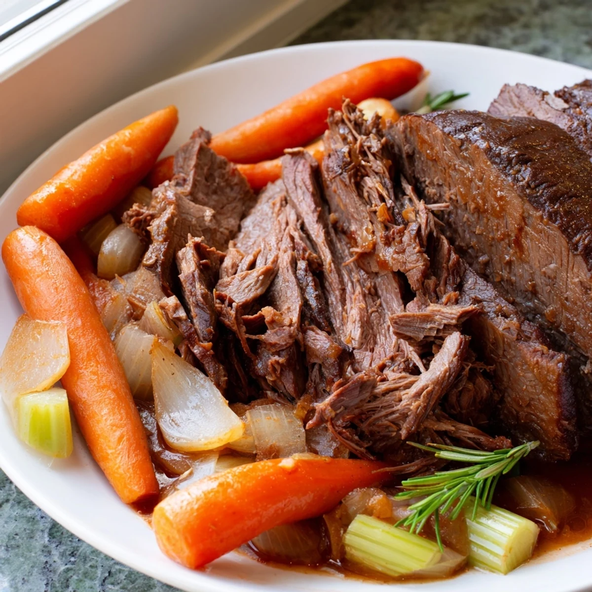 Hearty perfect pot roast plated with soft carrots and glossy brown gravy