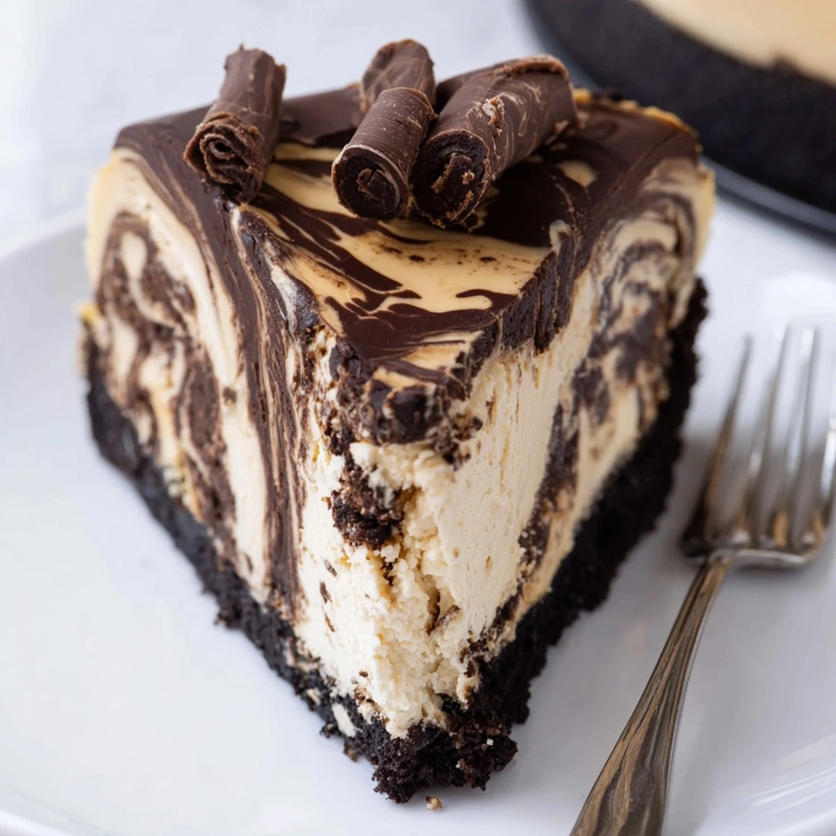Rich chocolate peanut butter cheesecake swirled with melted chocolate on a cookie crust