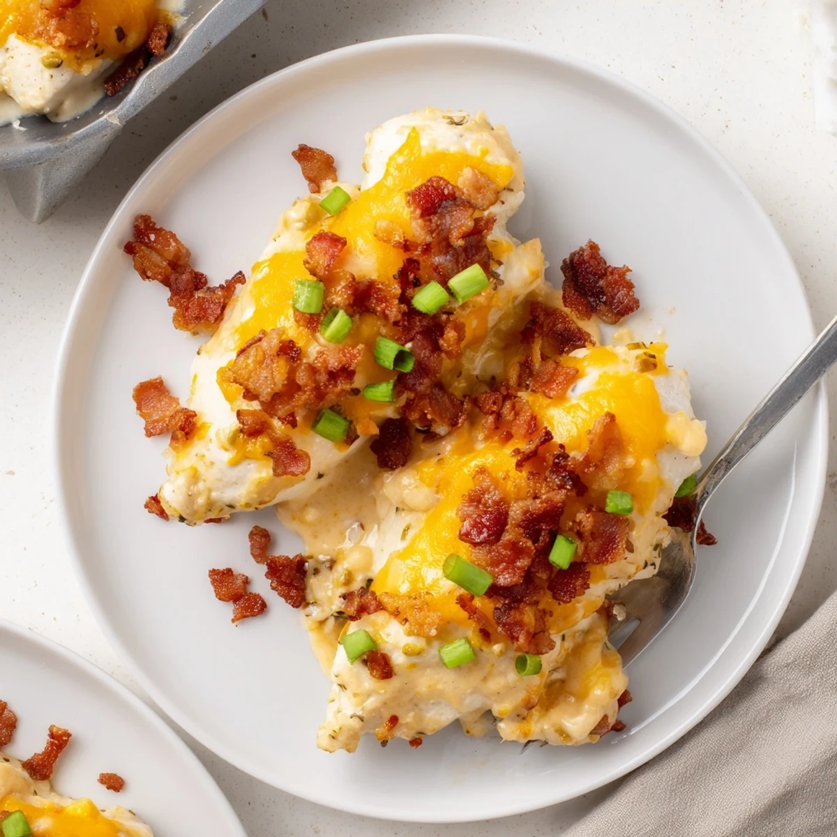 Creamy baked crack chicken with melted cheddar and crispy bacon in a bubbly baking dish